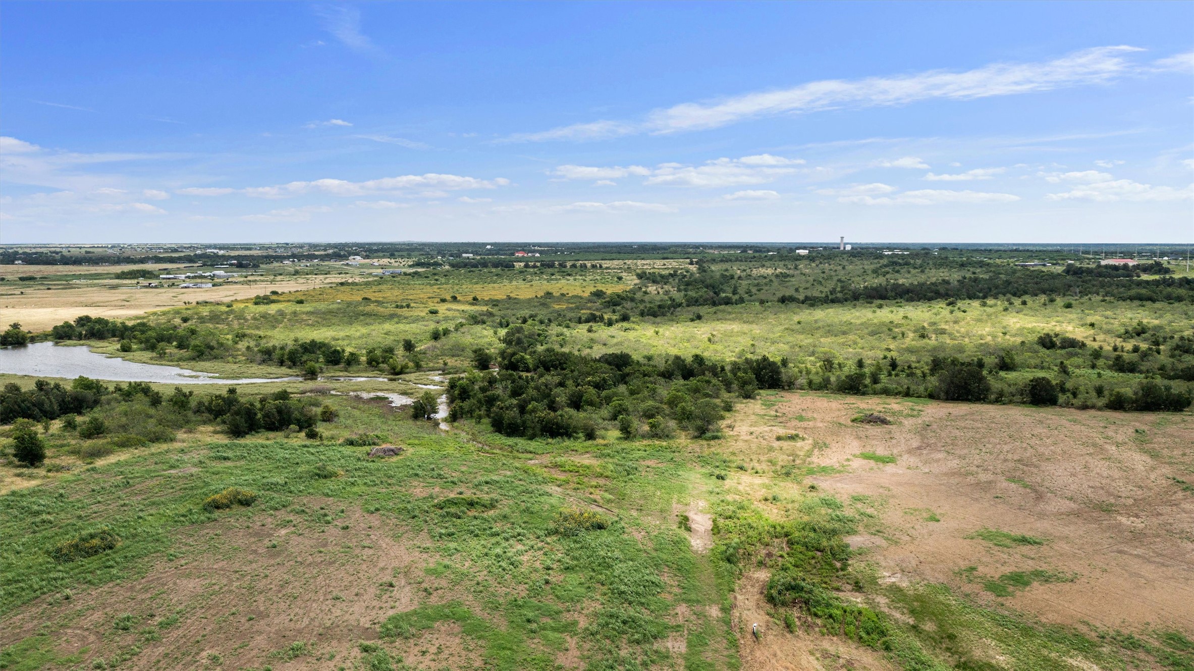 3315 County Road 463 Elgin, TX 78621 - Photo 14 of 32 Vast, verdant fields offer a tranquil escape with distant waters reflecting the boundless sky.