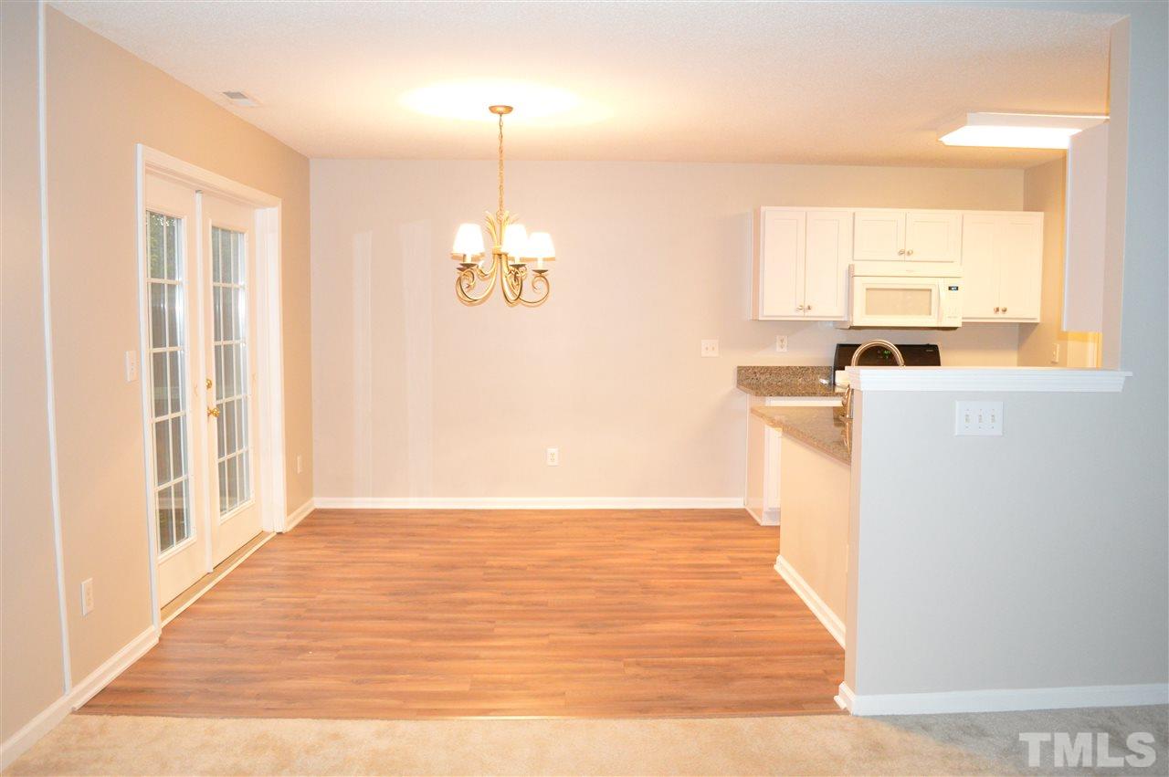 9121 Shallcross Way Raleigh, NC 27617 - Photo 3 of 10 a view of a kitchen with a window wooden floor and chandelier