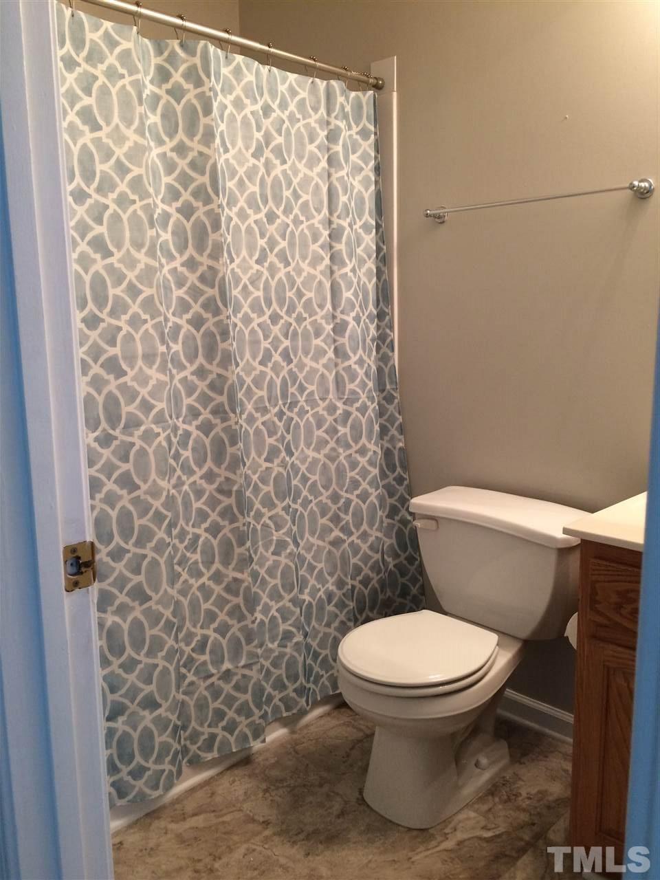 9121 Shallcross Way Raleigh, NC 27617 - Photo 8 of 10 a white toilet sitting next to a shower curtain