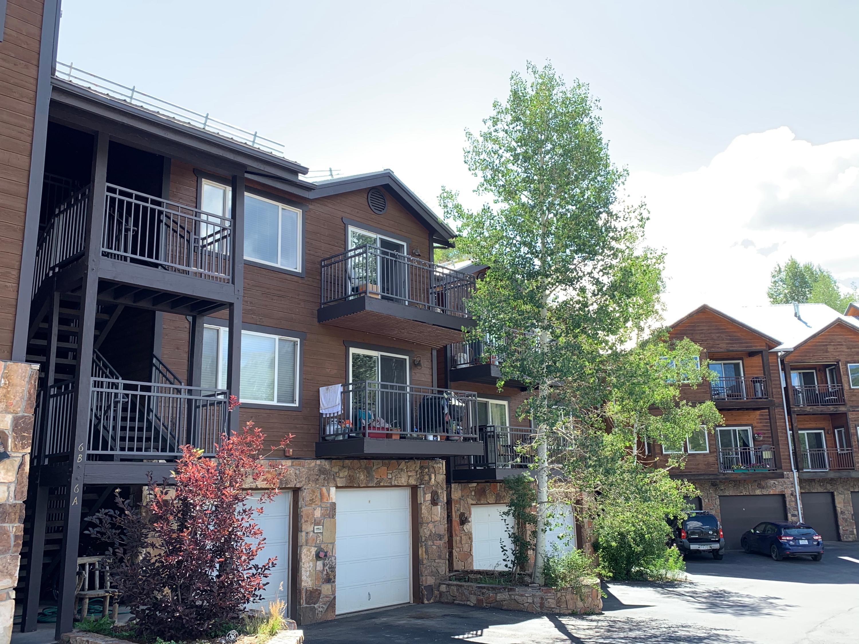 323 Adams Ranch Road, Unit 5B Mountain Village, CO 81435 - Photo 3 of 30 a front view of a house with a garden