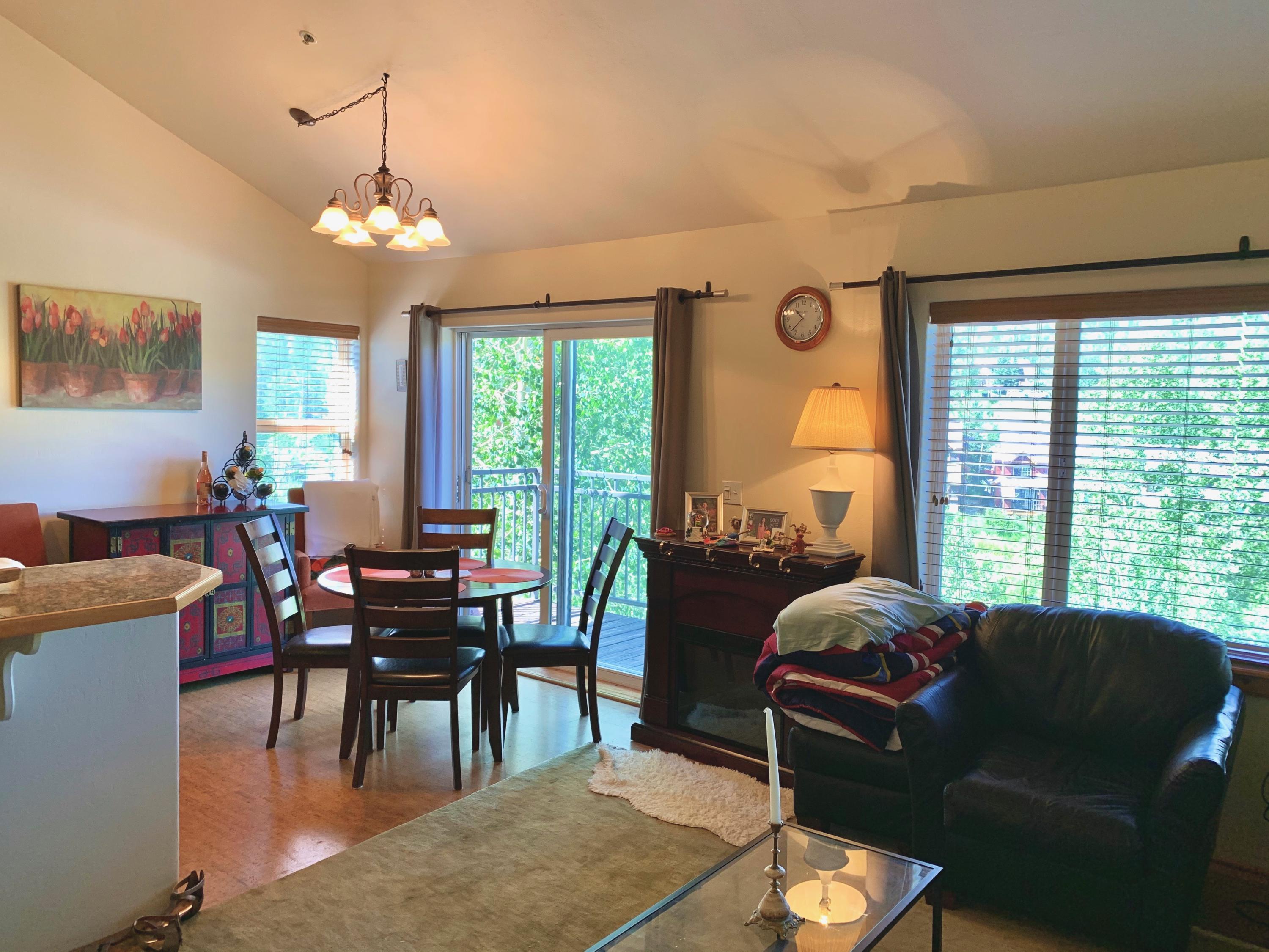 323 Adams Ranch Road, Unit 5B Mountain Village, CO 81435 - Photo 8 of 30 a living room with furniture a chandelier and a dining table