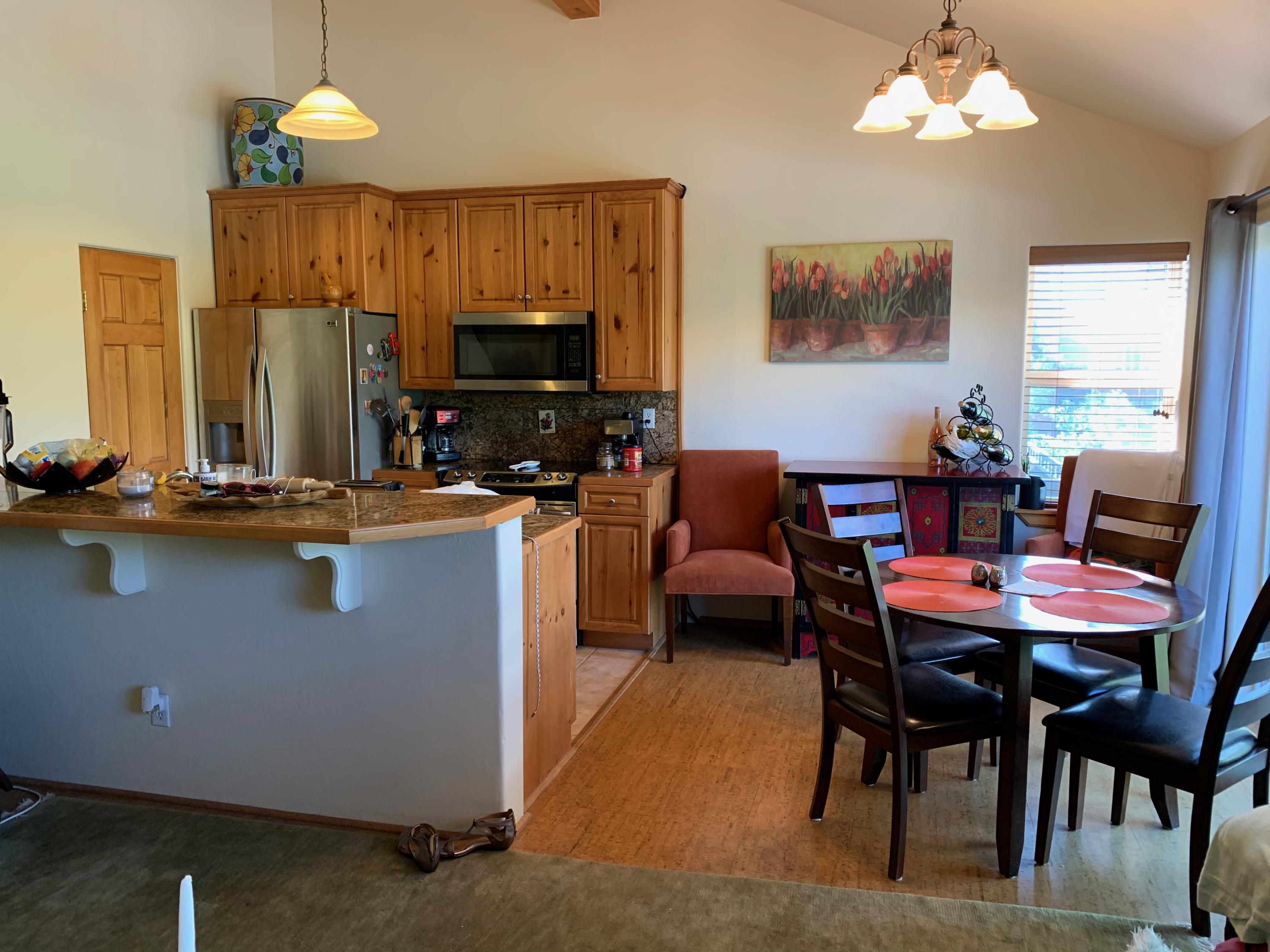 323 Adams Ranch Road, Unit 5B Mountain Village, CO 81435 - Photo 10 of 30 a dining room with wooden floor a chandelier a wooden table and chairs