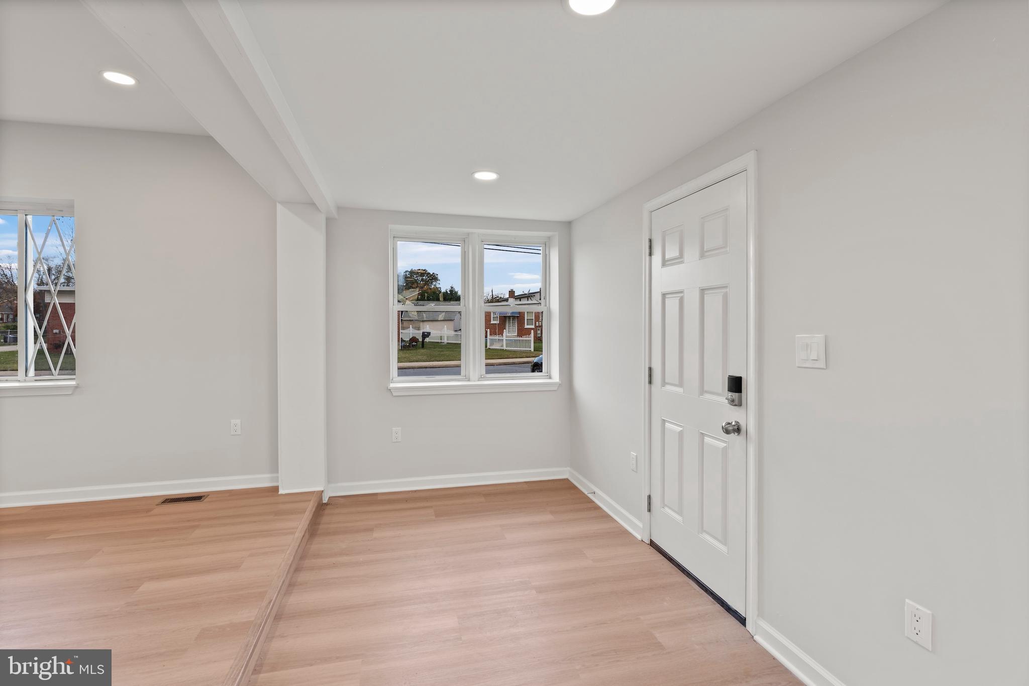 730 New Pittsburg Avenue, Unit 1 Baltimore, MD 21222 - Photo 7 of 27 an empty room with wooden floor and windows