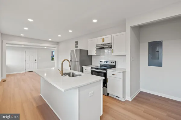 a kitchen with white cabinets appliances and sink