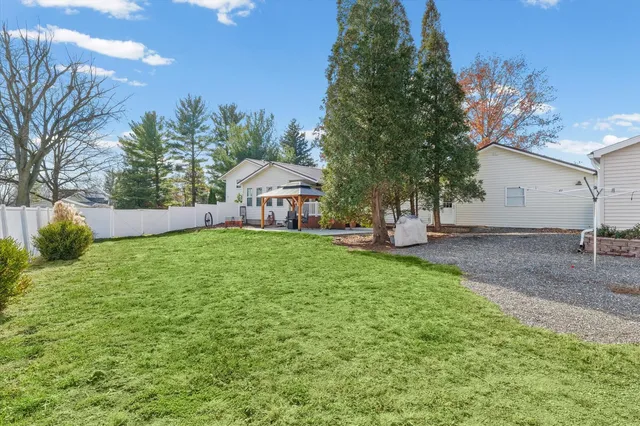 a view of a yard with plants and a bench