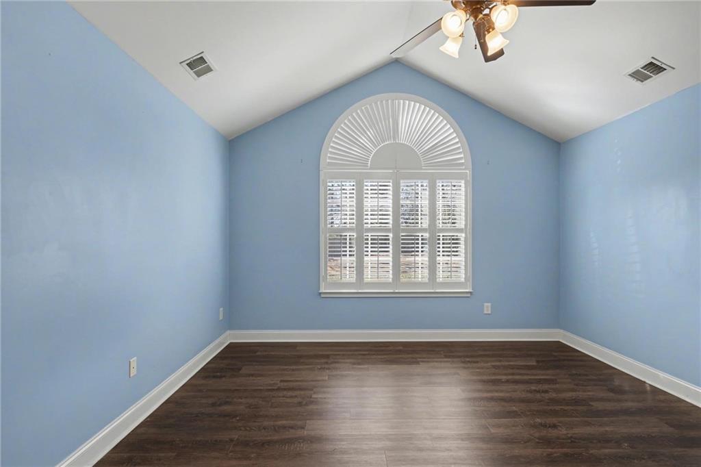 214 Highlands Ridge Place, Unit 3 Smyrna, GA 30082 - Photo 19 of 25 an empty room with wooden floor chandelier fan and window