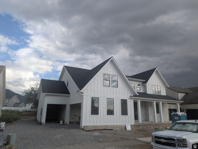 2771 West Aurora Avenue Mapleton, UT 84664 - Photo 2 of 39 Modern farmhouse-style exterior featuring white board and batten siding, dark shingle roofing, multiple gables, a covered front porch with white columns, and black-framed windows