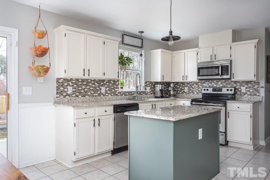 9312 Copernicus Court Raleigh, NC 27617 - Photo 12 of 30 Bright, white cabinets, SS appliances, granite countertops, tile backsplash, central island!