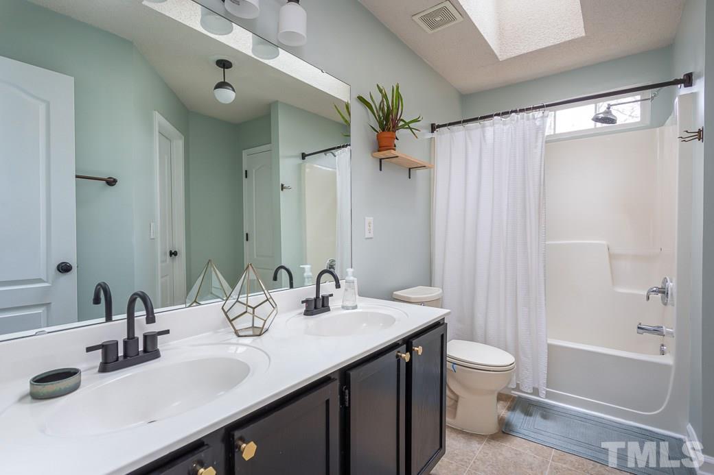 9312 Copernicus Court Raleigh, NC 27617 - Photo 20 of 30 Double sinks and a skylight.