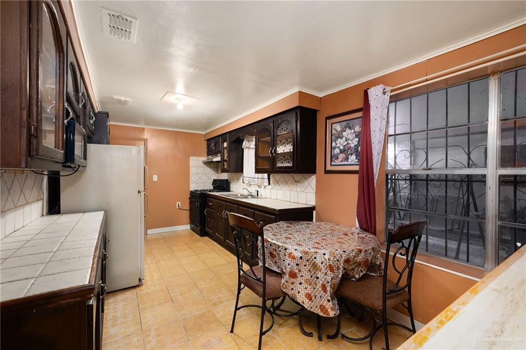 264 West Huisache Street Rio Grande City, TX 78582 - Photo 6 of 16 a living room with furniture a flat screen tv and a refrigerator