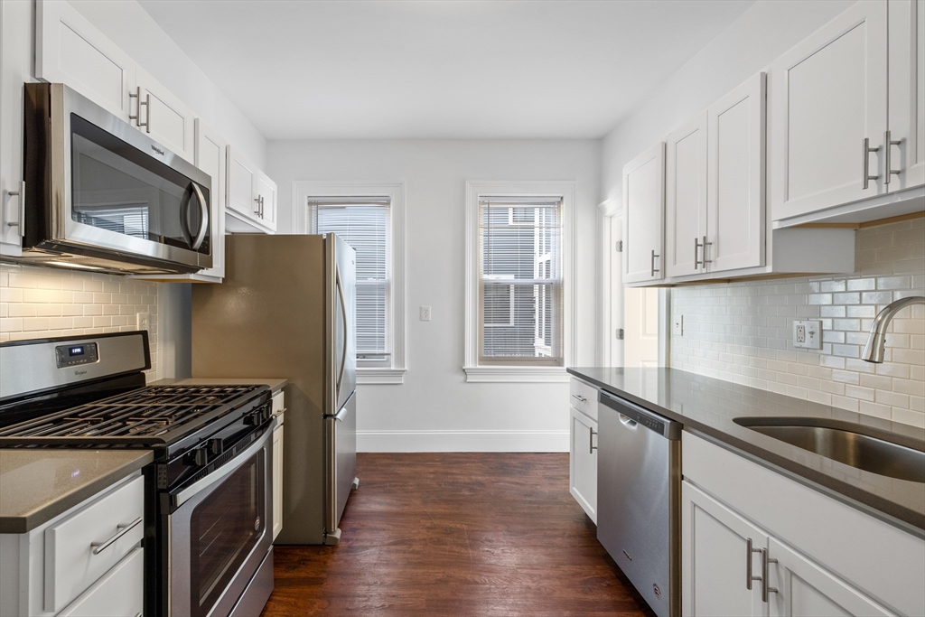 122 Columbia Street, Unit 3 Cambridge, MA 02139 - Photo 11 of 17 a kitchen with stainless steel appliances a sink stove and refrigerator