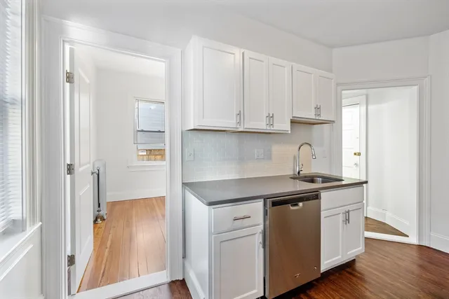 a kitchen with stainless steel appliances granite countertop a sink and a stove with white countertops