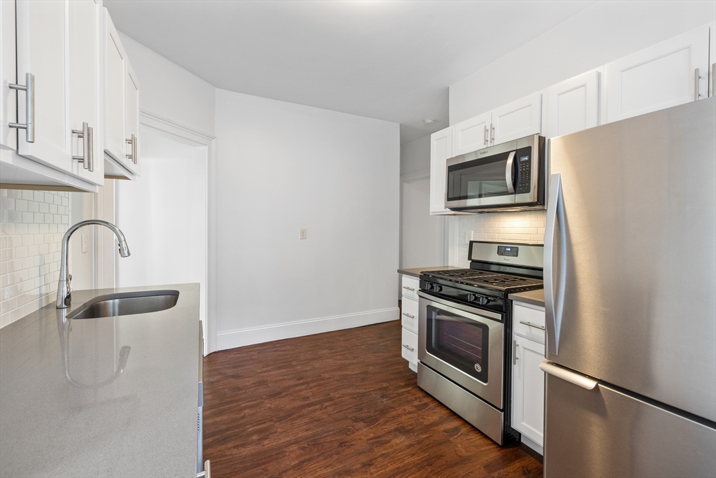 122 Columbia Street, Unit 3 Cambridge, MA 02139 - Photo 13 of 17 a kitchen with granite countertop a stove and a microwave