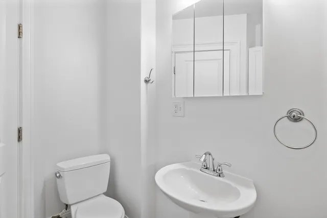 a bathroom with a toilet sink and mirror