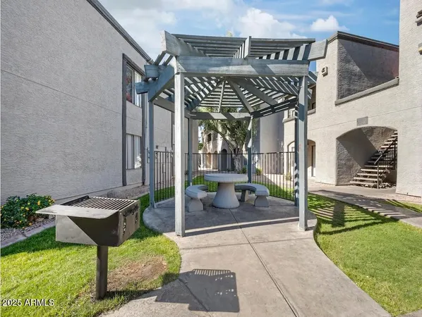 a view of a chairs and table in the patio with a backyard
