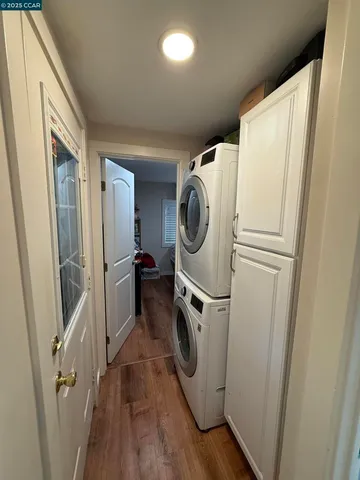 a storage room with wooden floor washer and dryer