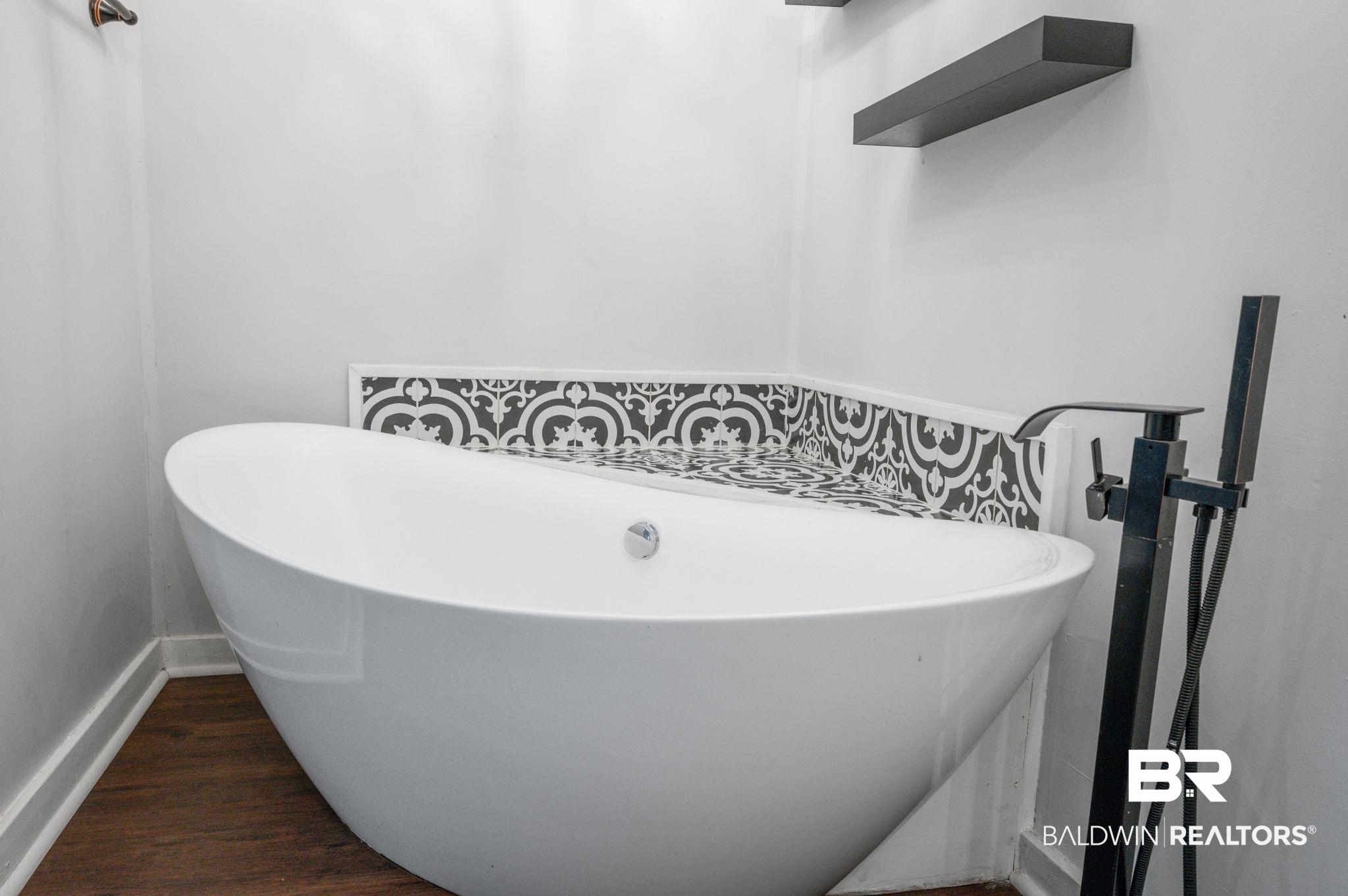 503 North Holly Street Foley, AL 36535 - Photo 14 of 23 Bathroom with hardwood / wood-style floors and a tub