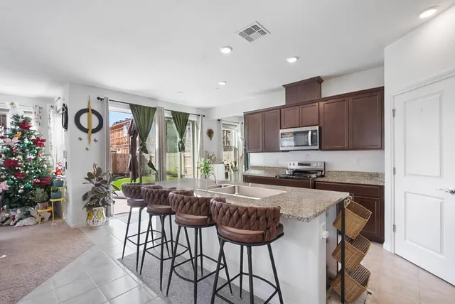 a kitchen with granite countertop a table and chairs in it