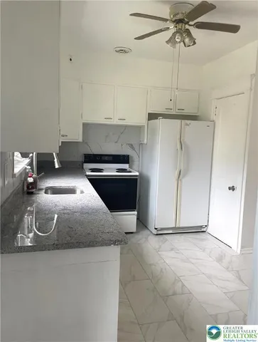 a kitchen with stainless steel appliances granite countertop a sink a stove and a refrigerator