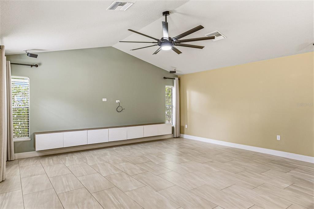 4821 Falcon Boulevard Cocoa, FL 32927 - Photo 19 of 48 a view of an empty room with wooden floor and a ceiling fan