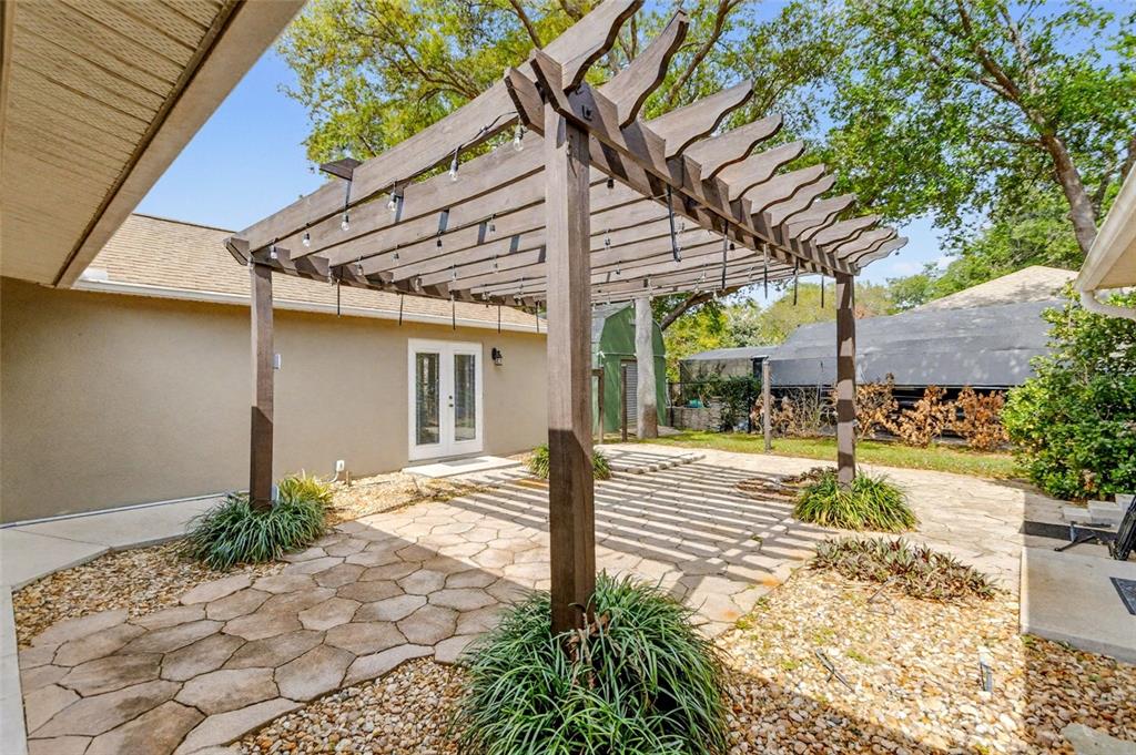 4821 Falcon Boulevard Cocoa, FL 32927 - Photo 10 of 48 a view of a patio with table and chairs potted plants and large tree