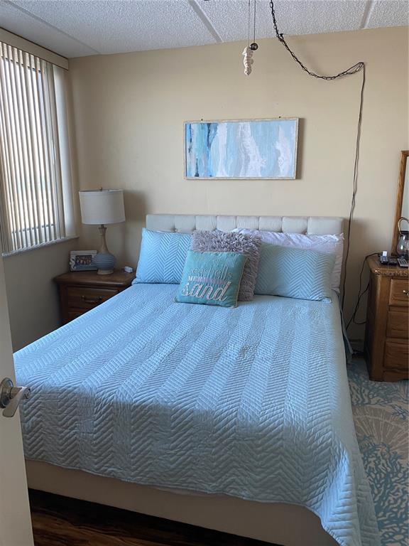 4453 South Atlantic Avenue, Unit 208 Ponce Inlet, FL 32127 - Photo 24 of 40 a bedroom with a bed and wooden floor