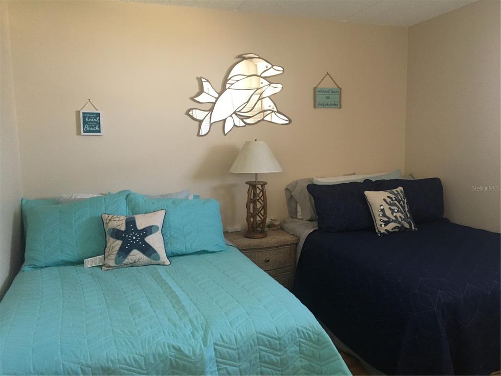 4453 South Atlantic Avenue, Unit 208 Ponce Inlet, FL 32127 - Photo 25 of 40 a bed room with a bed and a chandelier