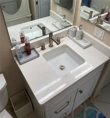 a bathroom with a sink a toilet and mirror