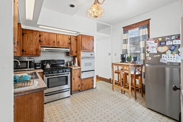 a kitchen with stainless steel appliances a stove a sink and a refrigerator