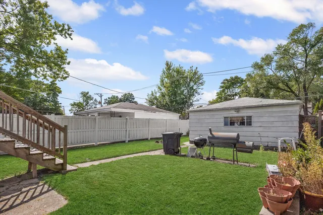 a view of a backyard with table and chairs potted plants and a palm tree