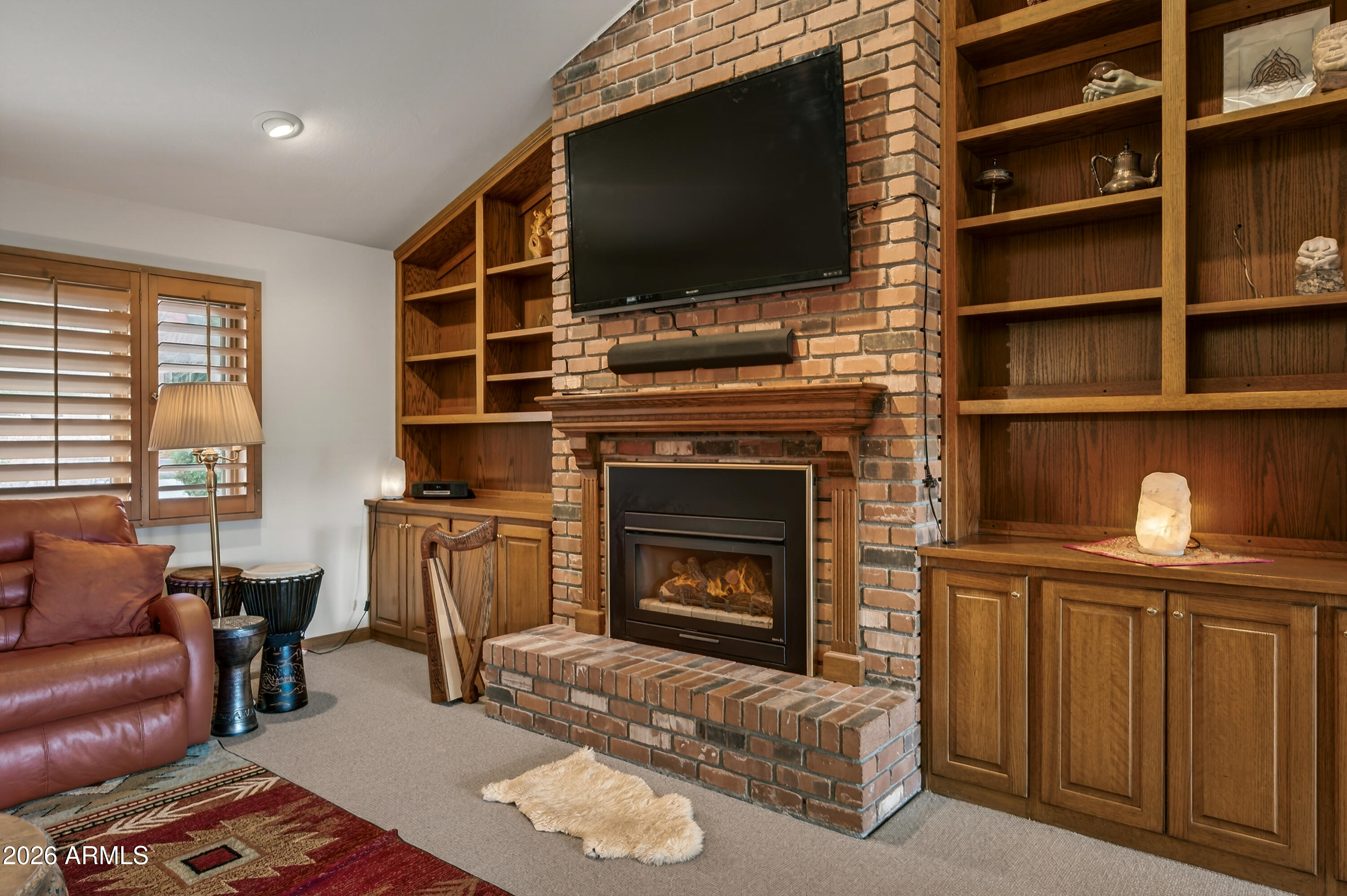 2215 Lariat Road Sedona, AZ 86336 - Photo 16 of 45 a living room with furniture a flat screen tv and a fireplace