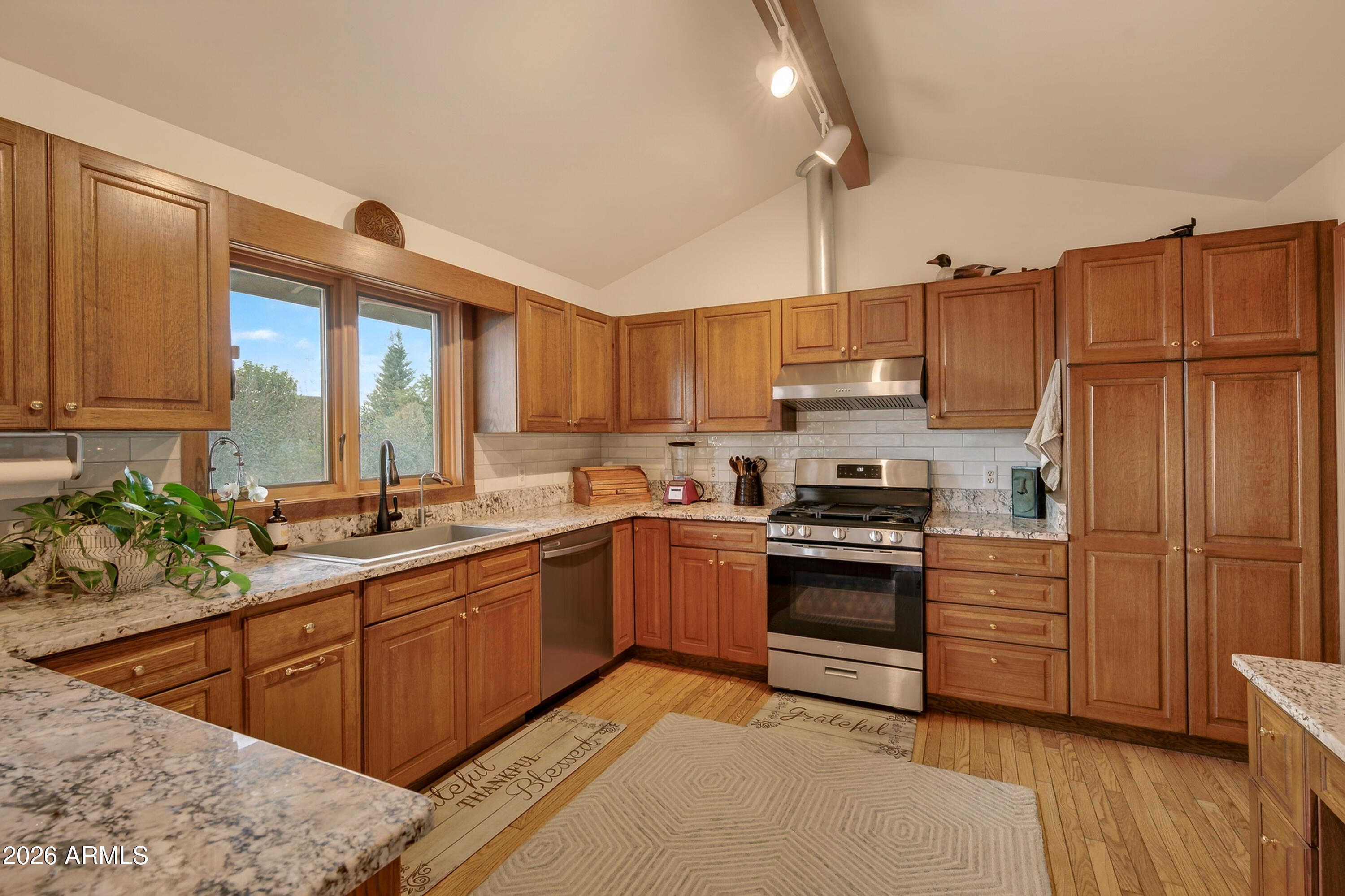 2215 Lariat Road Sedona, AZ 86336 - Photo 20 of 45 a kitchen with stainless steel appliances granite countertop a stove a sink dishwasher and a refrigerator