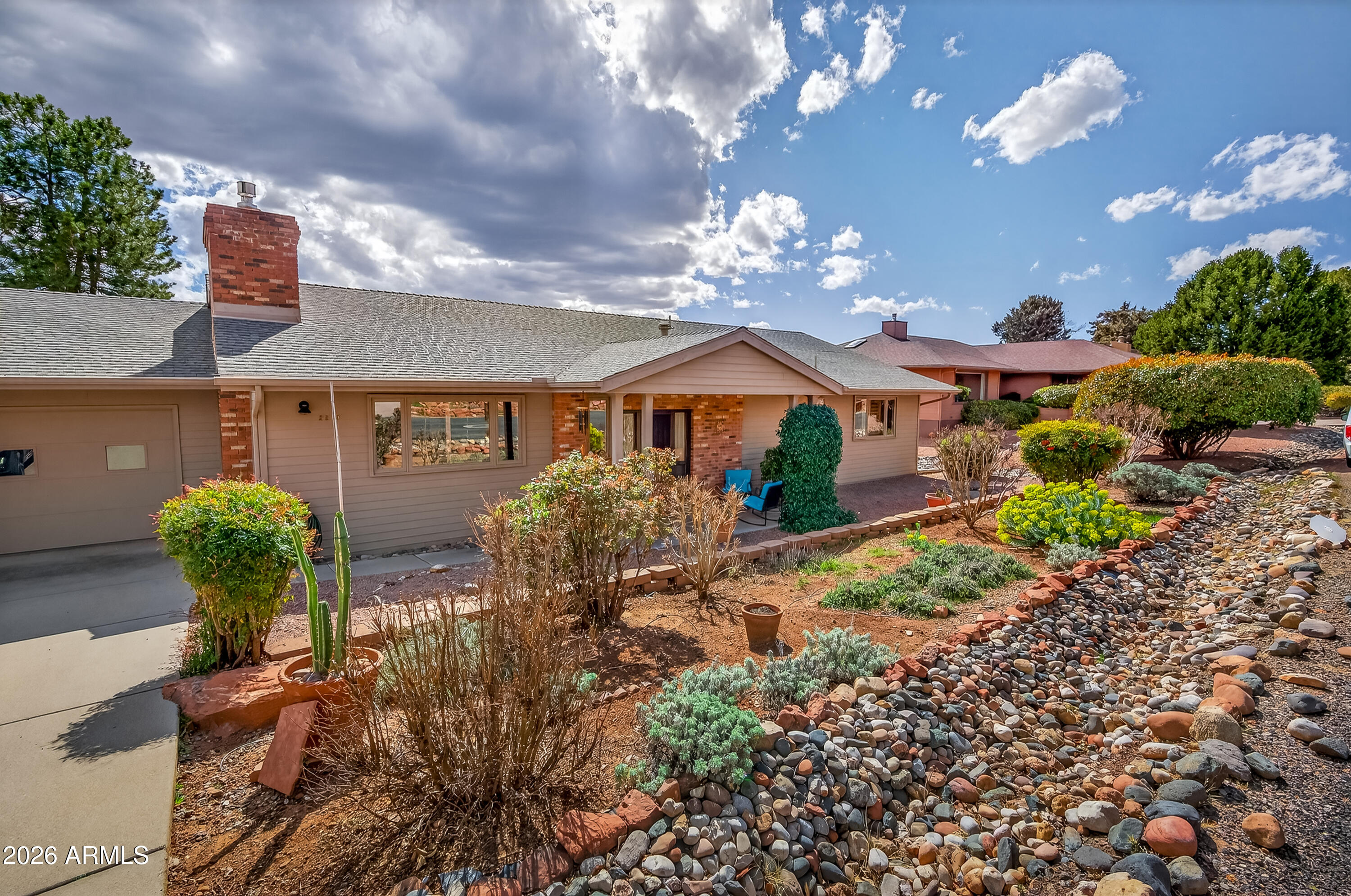 2215 Lariat Road Sedona, AZ 86336 - Photo 2 of 45 a front view of a house with garden