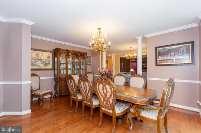 a dining room with furniture a chandelier and wooden floor