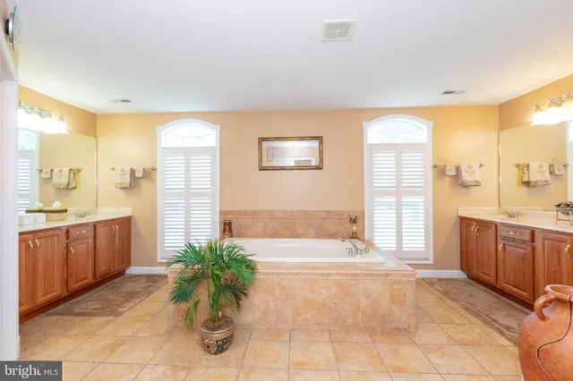 a spacious bathroom with a granite countertop tub sink and mirror