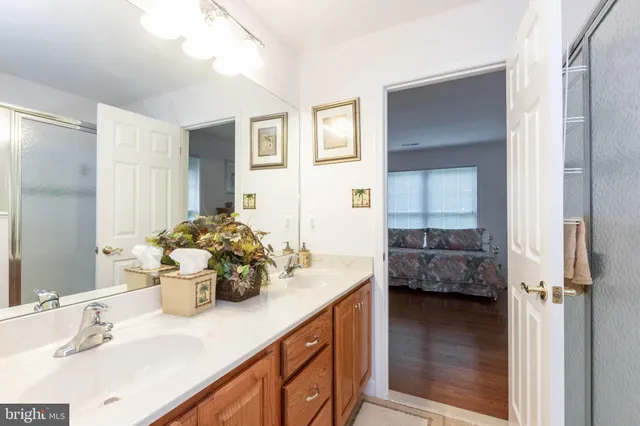 a kitchen with a sink and dishwasher a dining table with wooden floor