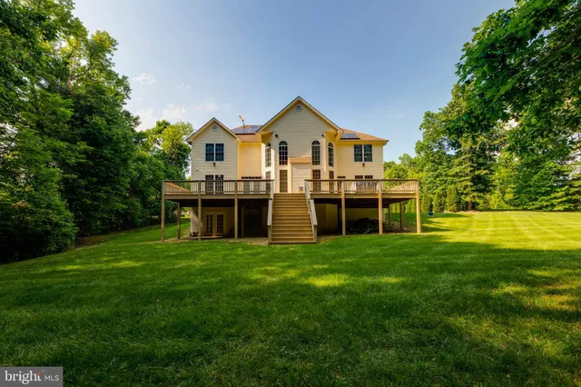 a front view of a house with a yard and trees