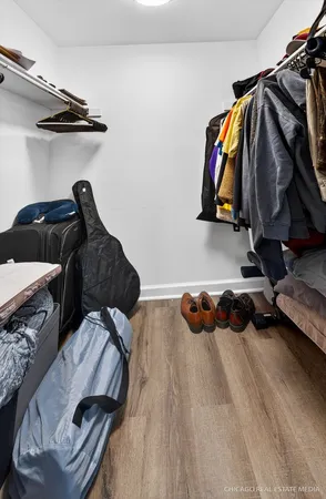 a view of walk in closet with clothes and shoes