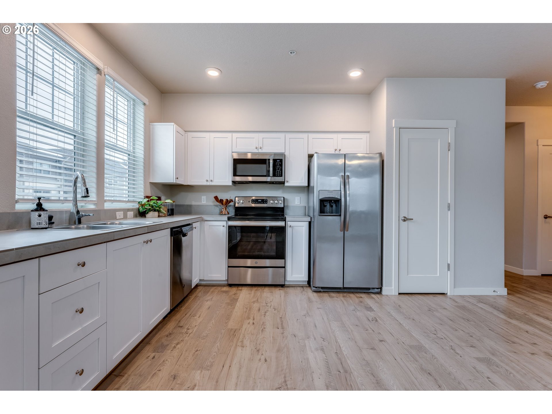 17149 Southwest Snowdale Street, Unit 103 Beaverton, OR 97007 - Photo 12 of 48 a kitchen with stainless steel appliances a refrigerator sink and cabinets