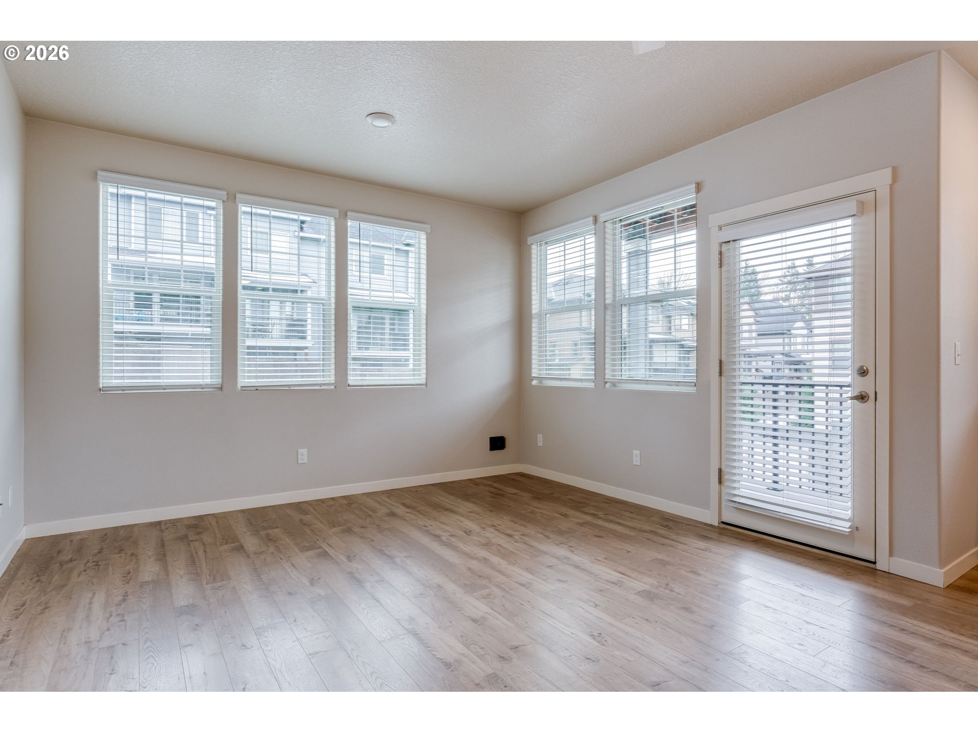 17149 Southwest Snowdale Street, Unit 103 Beaverton, OR 97007 - Photo 16 of 48 a view of an empty room with wooden floor and a window