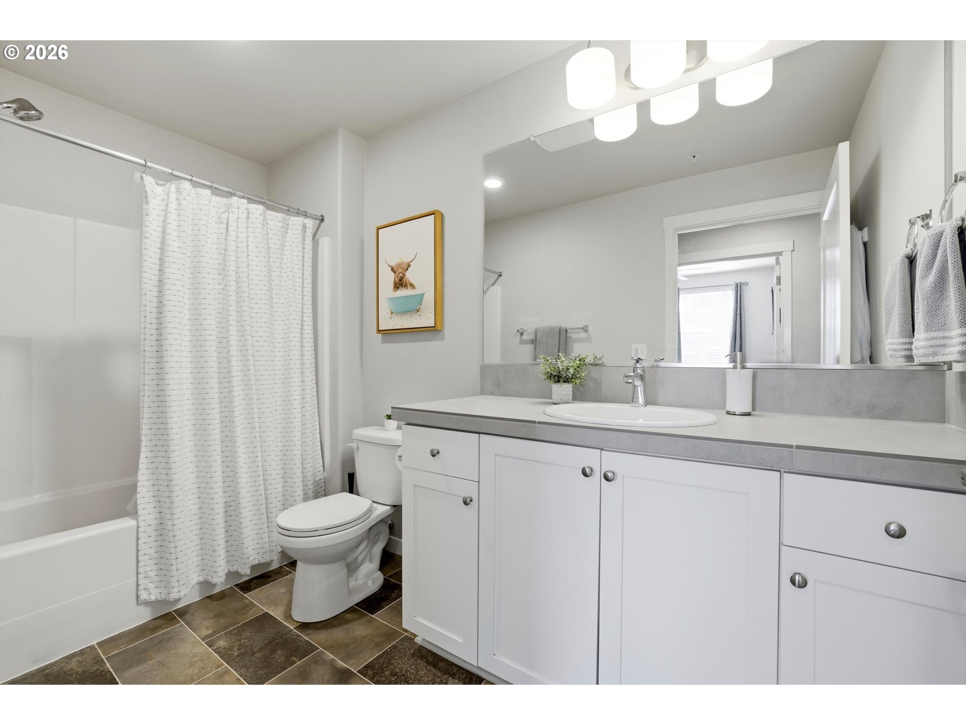 17149 Southwest Snowdale Street, Unit 103 Beaverton, OR 97007 - Photo 38 of 48 a bathroom with a sink a toilet a mirror and shower