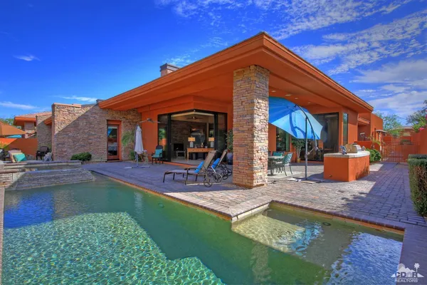 a view of a house with swimming pool and sitting area