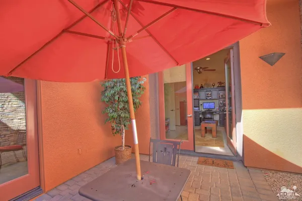 a patio with wooden floor a yard a table and chairs