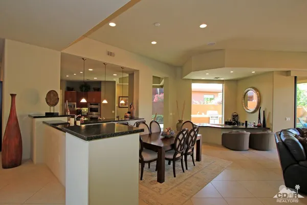 a living room with furniture kitchen view and a flat screen tv