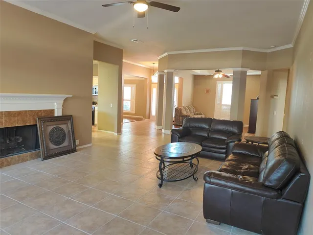 a living room with couches a fireplace and a chandelier