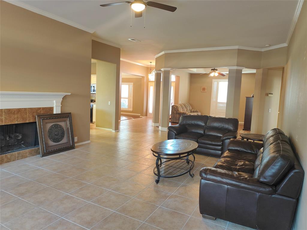 7900 Roaring Ridge Drive Plano, TX 75025 - Photo 13 of 34 a living room with couches a fireplace and a chandelier