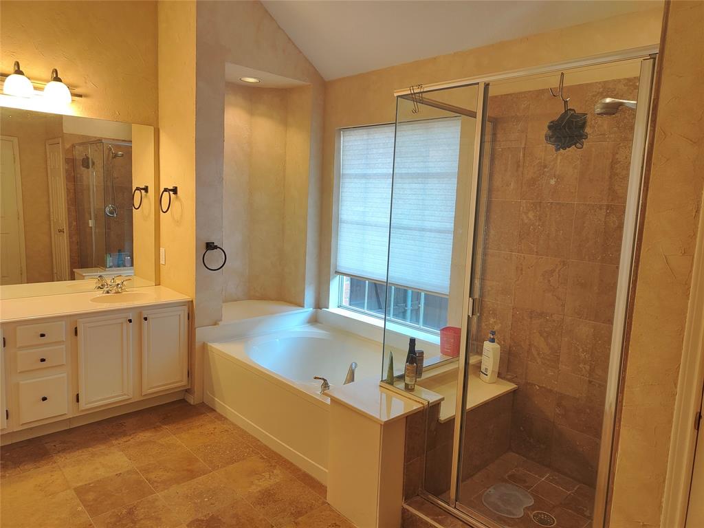 7900 Roaring Ridge Drive Plano, TX 75025 - Photo 23 of 34 a bathroom with a tub sink shower and mirror