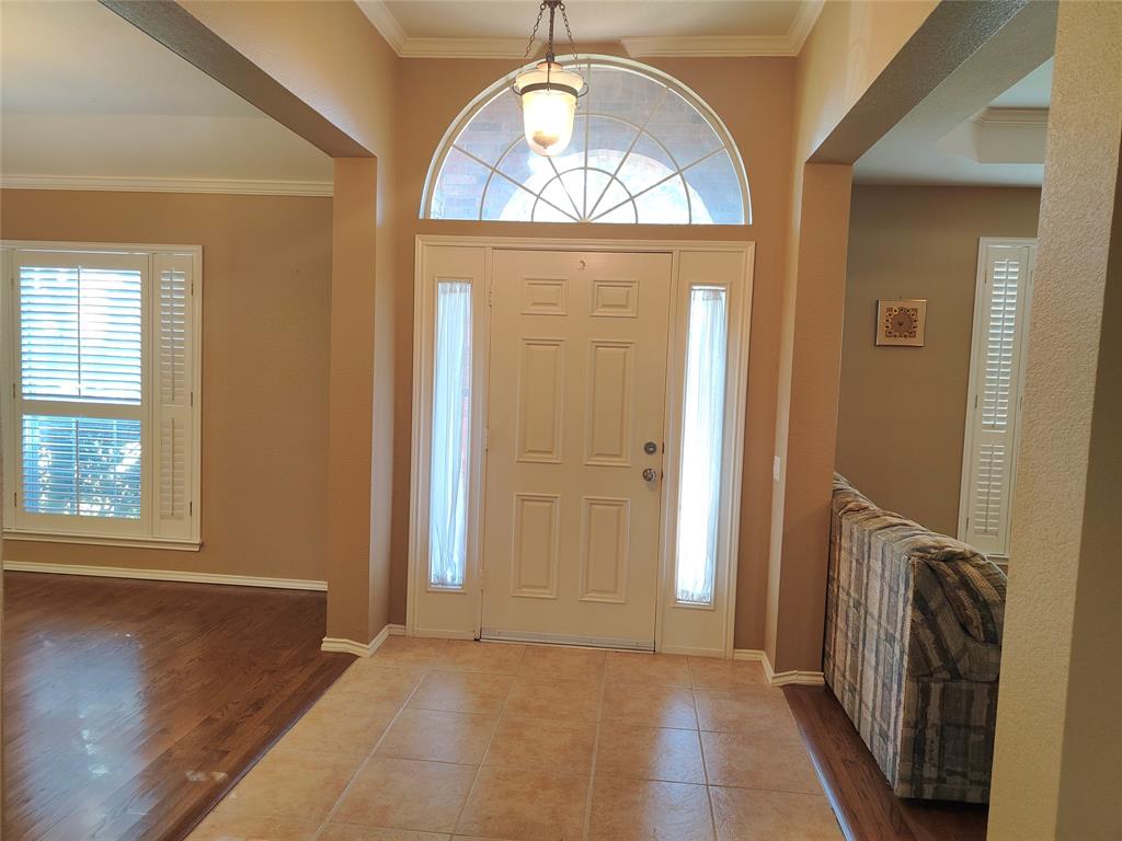 7900 Roaring Ridge Drive Plano, TX 75025 - Photo 3 of 34 an empty room with wooden floor mirror and windows
