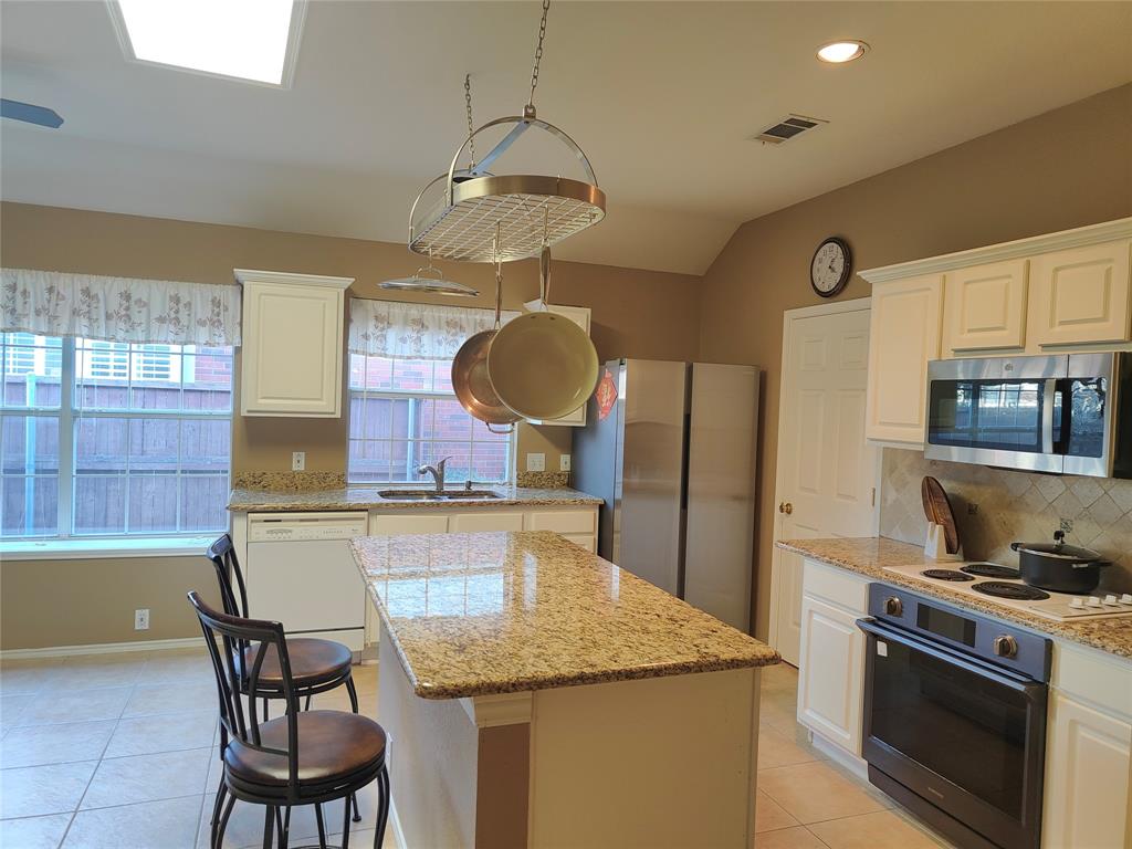 7900 Roaring Ridge Drive Plano, TX 75025 - Photo 6 of 34 a kitchen with stainless steel appliances granite countertop a sink a stove and a refrigerator