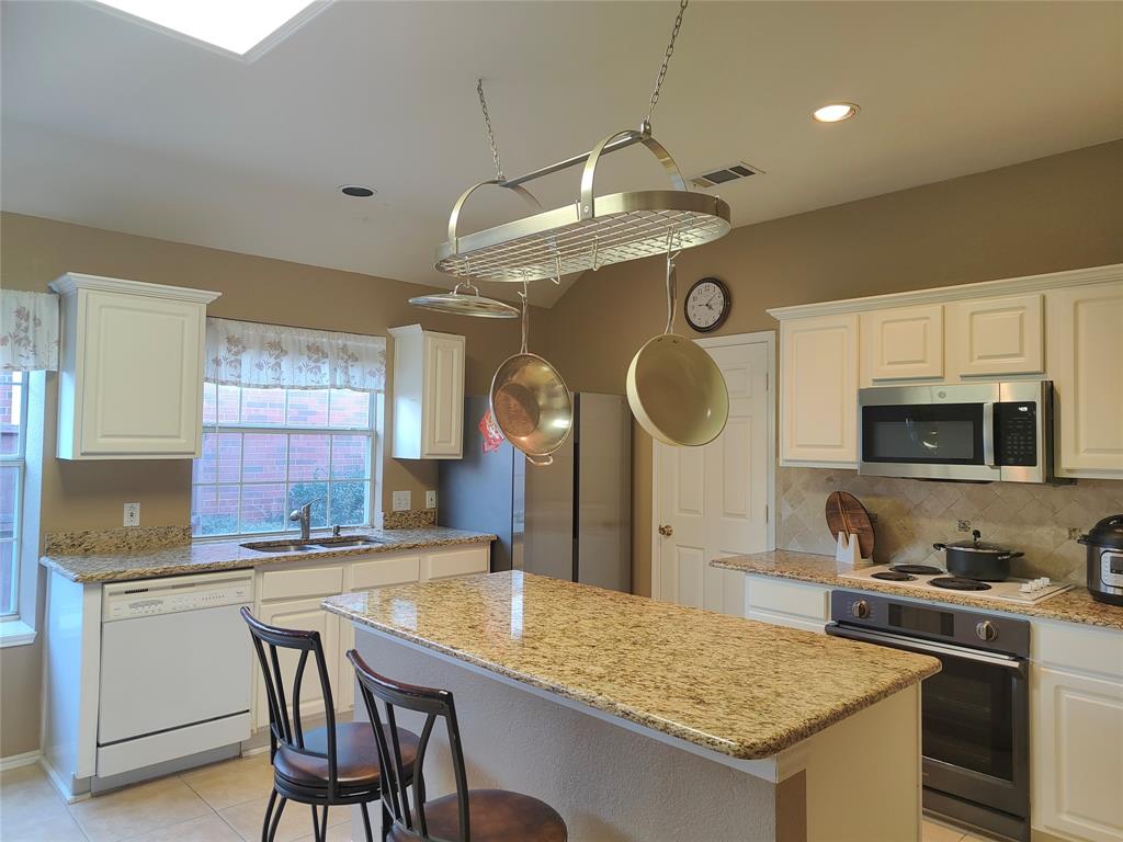 7900 Roaring Ridge Drive Plano, TX 75025 - Photo 8 of 34 a kitchen with stainless steel appliances granite countertop a stove a sink and a microwave
